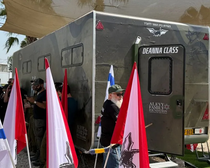 The Deanna Class mobile flight simulator unit, flags flying, at a dedication.