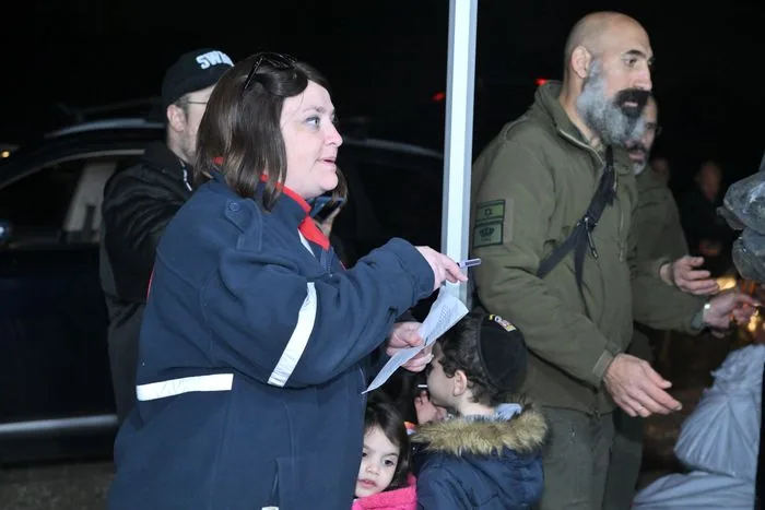 Tzion handing equipment to a soldier at a night distribution.